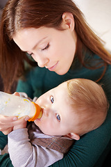 Image showing Face, woman and holding of baby with bottle for feeding in home for health, diet and nutrition with formula for hunger. Mother, watch and son for growth, development or milestone for future with care