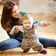 Image showing Mother, baby and smile for help with standing for development, motor skills or walking with assistance. Boy, infant or toddler with excited expression on face for future growth, milestone and support