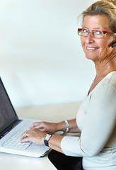 Image showing Mature woman, laptop and headset for call centre, company and remote work for telemarketing. Desk, internet and crm for job, web and support with smile, customer service and consulting clients