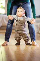 Image showing Mother, baby and helping with walking in home with support, trust and care for childhood development. Toddler, little boy and holding hand for motor skills, assistance and mobility in living room