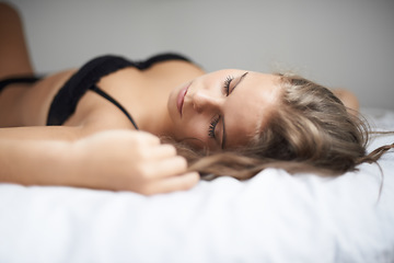 Image showing Lingerie, woman and bed with sleeping, rest and relax in a bedroom with underwear and calm. Sexy, fashion and confidence with nap at home on a blanket and sheets lying down with peace and bra