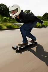 Image showing Man, skateboard and speed with motion blur in street with helmet for exercise, fitness and outdoor in summer. Person, skating and fast in road with thinking for extreme sports, training or moving