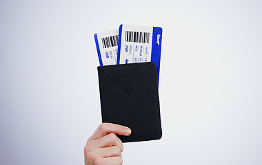 Image showing Hand, passport and flight tickets for travel closeup in studio on a gray background at the airport for a trip. Boarding pass, documents for immigration and a passenger getting ready for departure