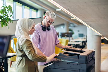 Image showing In a modern startup office, a business-minded Muslim woman wearing a hijab collaborates with her colleague, symbolizing diversity, empowerment, and success in the contemporary corporate world