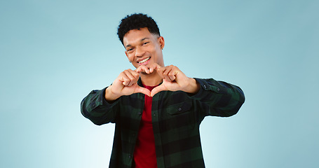 Image showing Heart, hands and portrait of man in studio with support, vote or feedback on blue background. Love, face and male model with finger frame for donation, charity or gratitude, appreciation or thank you