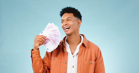 Image showing Happy man, winner and money fan with success, bonus or winning, college loan or cashback ideas in studio. Excited student thinking of cash, savings or scholarship funding isolated on blue background