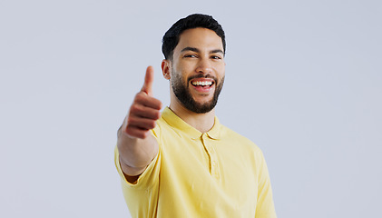 Image showing Thumbs up, portrait and man in studio for agreement, winning achievement and celebrate deal on white background. Happy indian model, emoji and like sign for feedback, yes and thank you for excellence