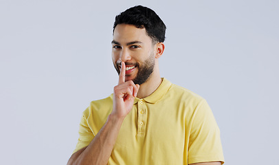 Image showing Secret, happy man and portrait in studio for sign of privacy, surprise sales and confidential deal on white background. Indian model with finger on lips for quiet, gossip and emoji to whisper news