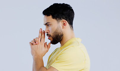 Image showing Finger gun, pointing and profile of man in studio with aim for target, shooting and spy on blue background. Secret agent, mockup space and face of person with hand gesture for pistol or weapon