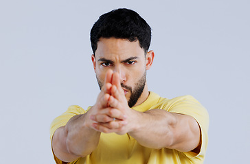 Image showing Finger gun, pointing and portrait of man in studio with aim for target, shooting and spy on blue background. Secret agent, mockup space and face of person with hand gesture for pistol or weapon