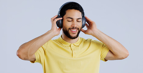 Image showing Man, music and headphones in studio for freedom, audio subscription and streaming multimedia playlist on white background. Happy indian model listening to peaceful podcast, hearing sound and radio