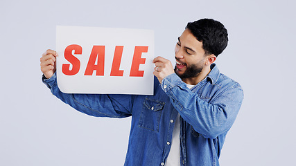 Image showing Man, sale and excited with board in studio mockup, shopping discount and advertising retail announcement. Young person, arab and marketing for deal promotion with product launch by white background