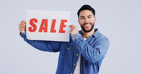 Image showing Happy man, portrait and sale sign for discount, promotion or banner against a gray studio background. Male person or model smile with billboard or poster for advertising or marketing store promo