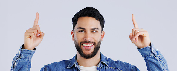 Image showing Happy man, portrait and pointing up on mockup for deal, advertising or marketing against a gray studio background. Face of male person or model showing notification, alert or sale for discount promo
