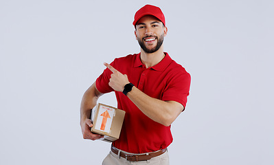 Image showing Courier man, box and studio portrait with pointing, smile and happy for delivery, shipping or supply chain. Logistics expert, happy and cardboard package for commercial job with product by background