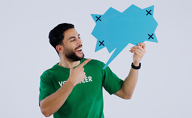 Image showing Man, speech bubble and volunteering in studio with paper, point or smile for opinion by background. Person, sign or poster with mockup space, tracking markers or feedback for promotion, quote or idea