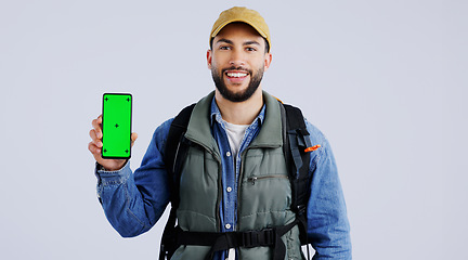 Image showing Happy man, backpack and phone green screen on mockup or hiking app against a studio background. Portrait of male person or hiker smile with bag and showing mobile smartphone display or travel tips
