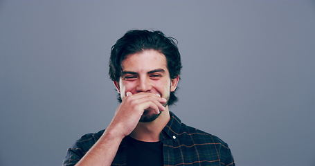 Image showing Face, comedy or happy man laughing at joke or crazy humor in studio isolated on gray background. Cover mouth, goofy guy or silly male person with a funny smile, joy or positive energy to relax alone