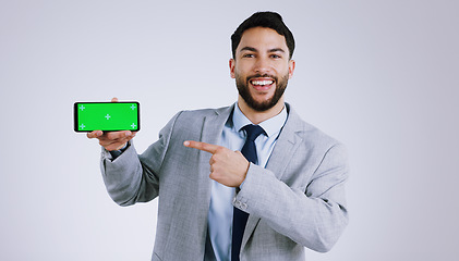 Image showing Business man, mobile green screen and presentation for social media, career software or job registration in studio. Portrait of corporate worker pointing to phone app or mockup on a white background