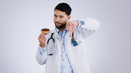 Image showing Man, doctor and thumbs down for donut choice in studio and unhealthy snack in mockup. Mexican person, nutritionist and portrait or no, advice and opinion on diet, fail and food by gray background