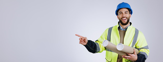 Image showing Portrait, pointing and man engineer with blueprint in studio with mockup space for advertising. Happy, smile and male industrial worker with architect designs and show hand gesture by gray background