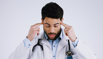 Image showing Man, doctor and headache in stress, anxiety or burnout for overworked against a white studio background. Male person, medical surgeon or nurse with migraine in depression, mental health or pressure