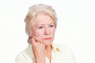 Image showing Negative nostalgia. Closeup of a depressed senior woman with her hand to her cheek looking away sadly - Isolated on White.