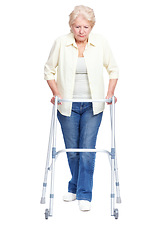 Image showing Taking it one step at a time ...Full-length of a senior woman focusing on pushing her walker while isolated on white.