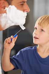 Image showing Carefully shaving Dads beard. A young boy helping his father shave his beard.