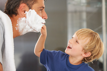 Image showing Giving him a clean shave. A young boy shaving his fathers beard.