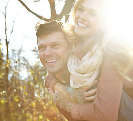 Image showing Having fun in the woods. A happy man piggybacking his girlfriend while spending time in the woods.