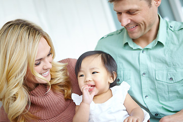 Image showing Shes captured their hearts. A happy couple spending time with their beautiful adopted daughter while at home.