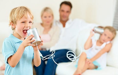 Image showing Can you hear me now. A little boy shouting loudly into a tin can connected to another that his sister is holding.