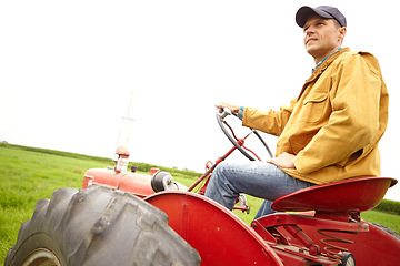 Image showing Sitting in contemplation. A farmer sitting on his tractor and looking over a open field with copyspace.