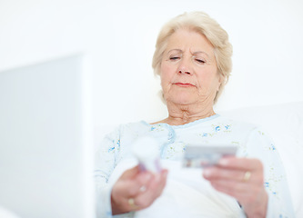 Image showing Internet transactions ensure she has her medication - Senior health. Elderly hospital patient prepares to make a medicinal purchase off of the internet with her credit card.