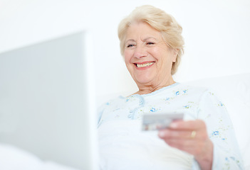 Image showing Keeping up with payments is a weight off her shoulders. Elderly hospital patient prepares to make a purchase off of the internet with her credit card.