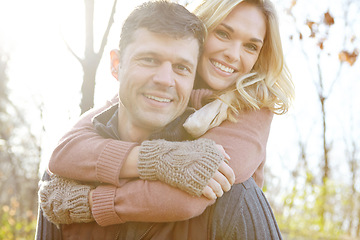 Image showing Enjoying a warm embrace. A happy man piggybacking his girlfriend while spending time in the woods.