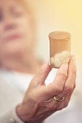 Image showing Taking medicine for her chronic condition. an elderly woman holding a container of medicine.