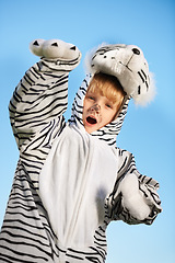 Image showing Roar. Little kid wearing a tiger costumer with his arms raised while roaring.