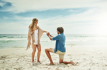 Image showing Will you make me the happiest man in the world. Full length shot of a young man proposing to his girlfriend on the beach.
