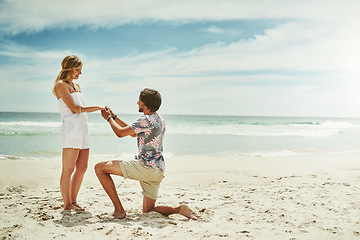 Image showing Will you be my wife. Full length shot of a young man proposing to his girlfriend on the beach.