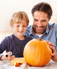 Image showing That looks really great. A father and son marking a pumpkin at home for halloween.