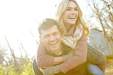 Image showing This is such fun. A happy man piggybacking his girlfriend while spending time in the woods.