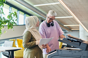 Image showing In a modern startup office, a business-minded Muslim woman wearing a hijab collaborates with her colleague, symbolizing diversity, empowerment, and success in the contemporary corporate world