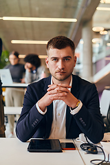 Image showing In a modern office setting, a determined director sits confidently at his desk with crossed arms, exemplifying professionalism, leadership, and unwavering resolve in the contemporary corporate world