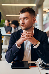 Image showing In a modern office setting, a determined director sits confidently at his desk with crossed arms, exemplifying professionalism, leadership, and unwavering resolve in the contemporary corporate world