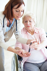 Image showing Knowledge is empowering - Senior Care. A caring nurse helps an elderly female patient check her blood sugar levels herself.