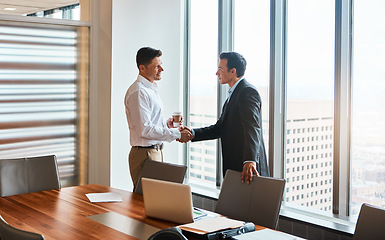 Image showing The places well go...two businessmen shaking hands in a corporate office.