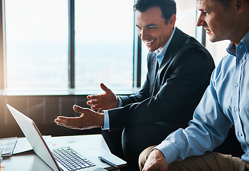 Image showing Heres all the information we need. two businessmen having a discussion while sitting by a laptop.