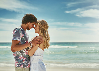 Image showing Some moments last a lifetime. an affectionate young couple embracing on the beach.